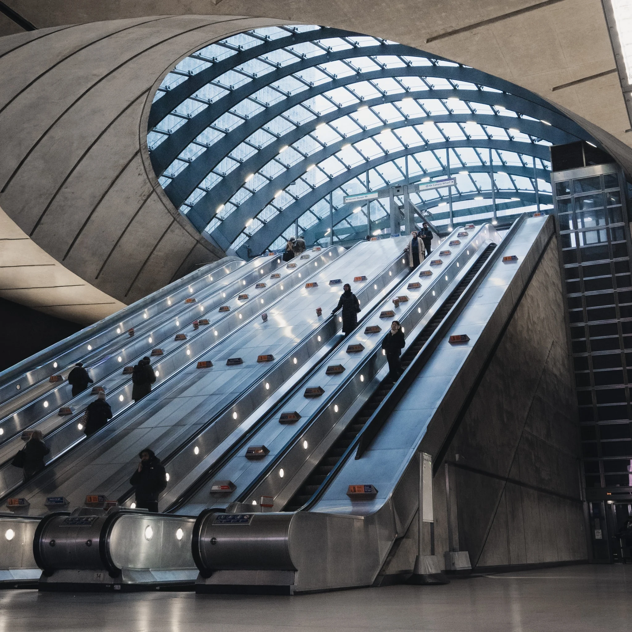 Escalators and curved glass architecture inside a modern station