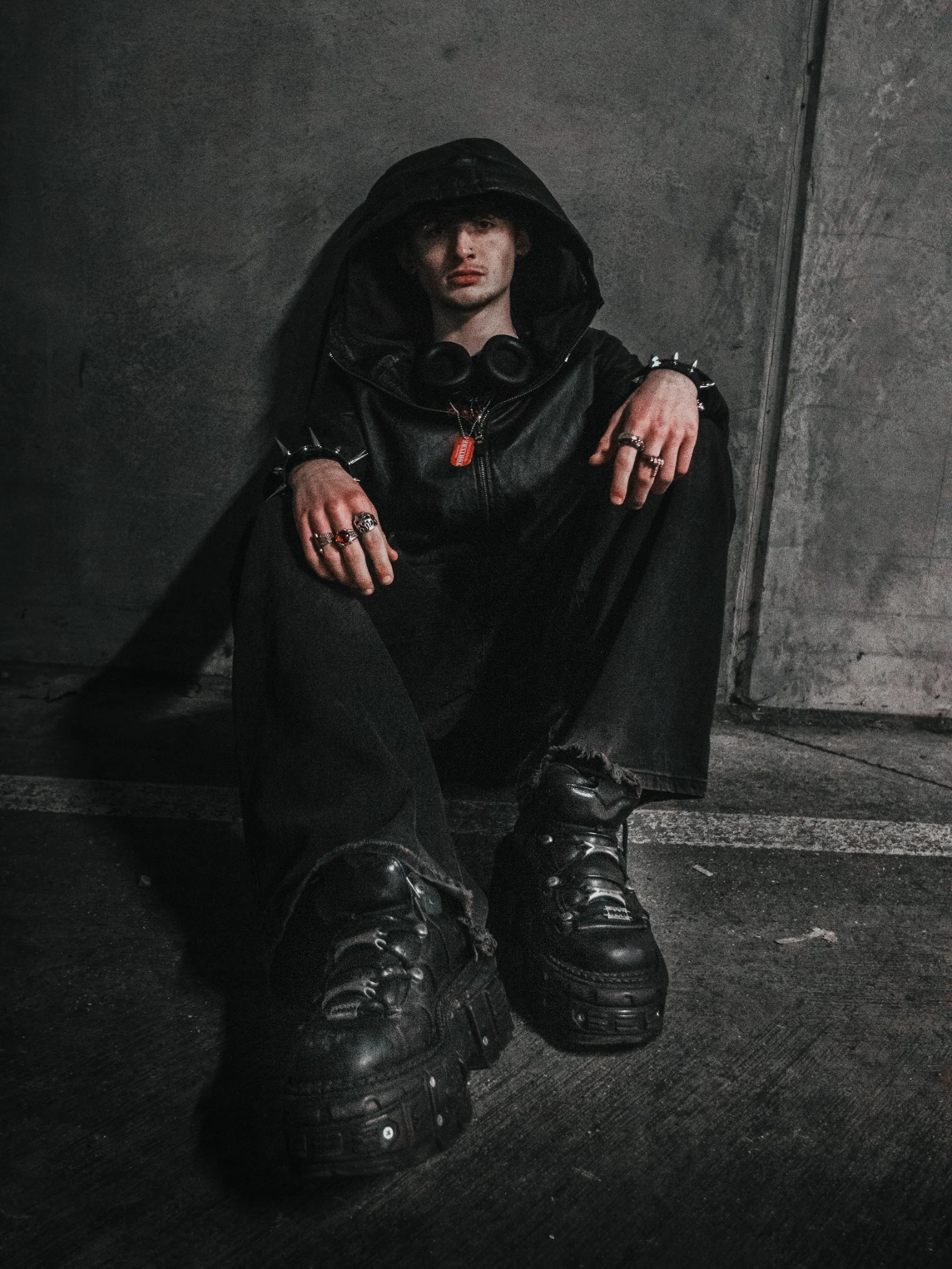 Editorial portrait of a seated man against an urban concrete background