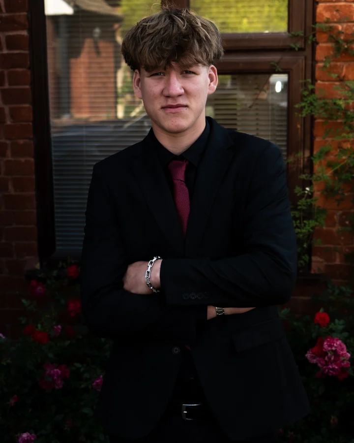 Individual prom portrait in a black suit and red tie