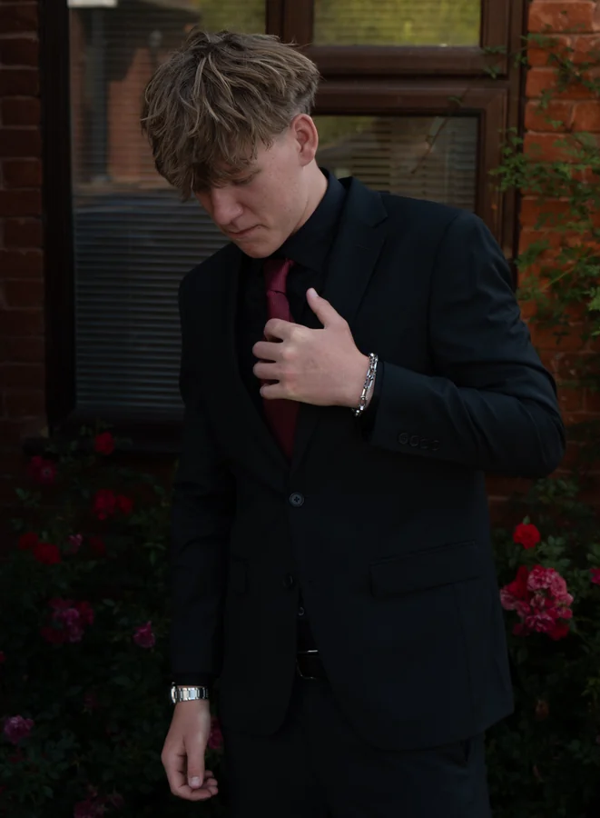 Portrait adjusting a red tie before the prom
